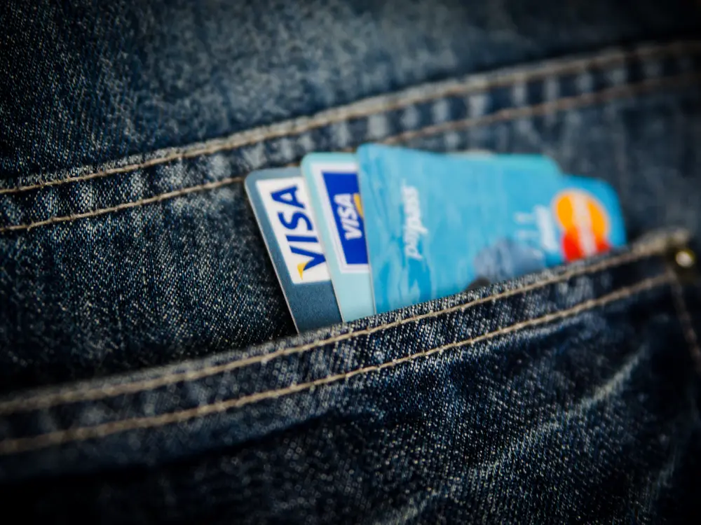 Visa and Mastercard credit cards tucked in a jeans pocket, everyday lifestyle shot