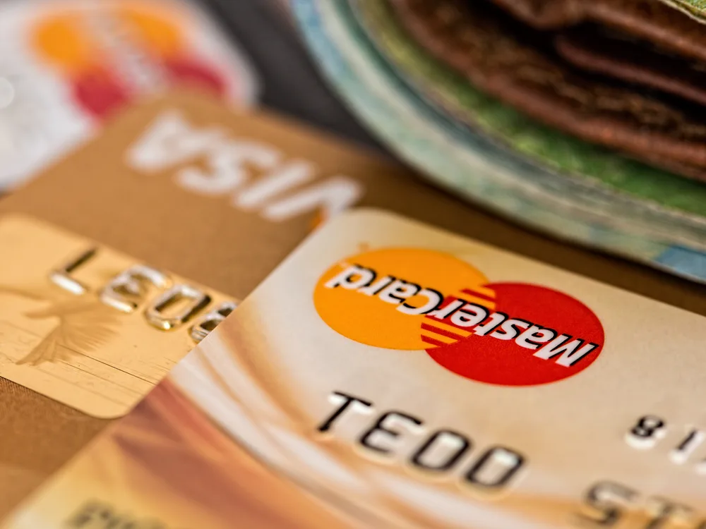 Mastercard credit card prominent in foreground with Visa card angled behind, closeup of both card logos